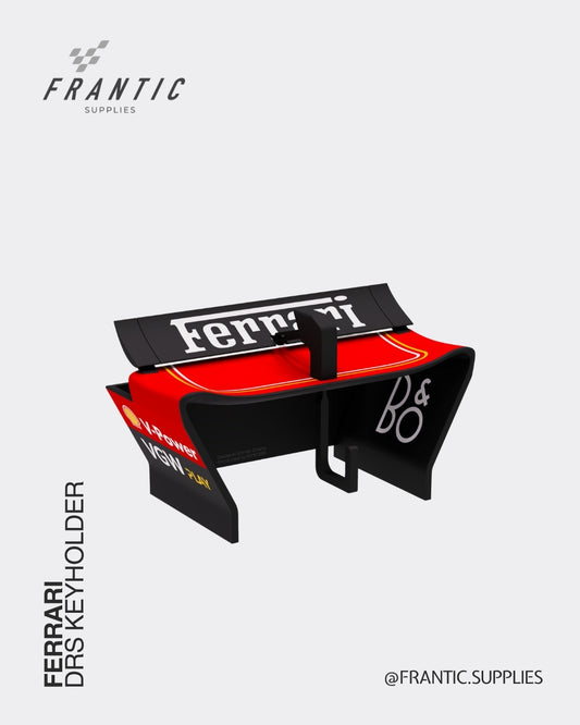 Ferrari DRS keyholder with red and black wing-shaped design featuring Ferrari branding and B&O logos, displayed on a white background, by Frantic Supplies.